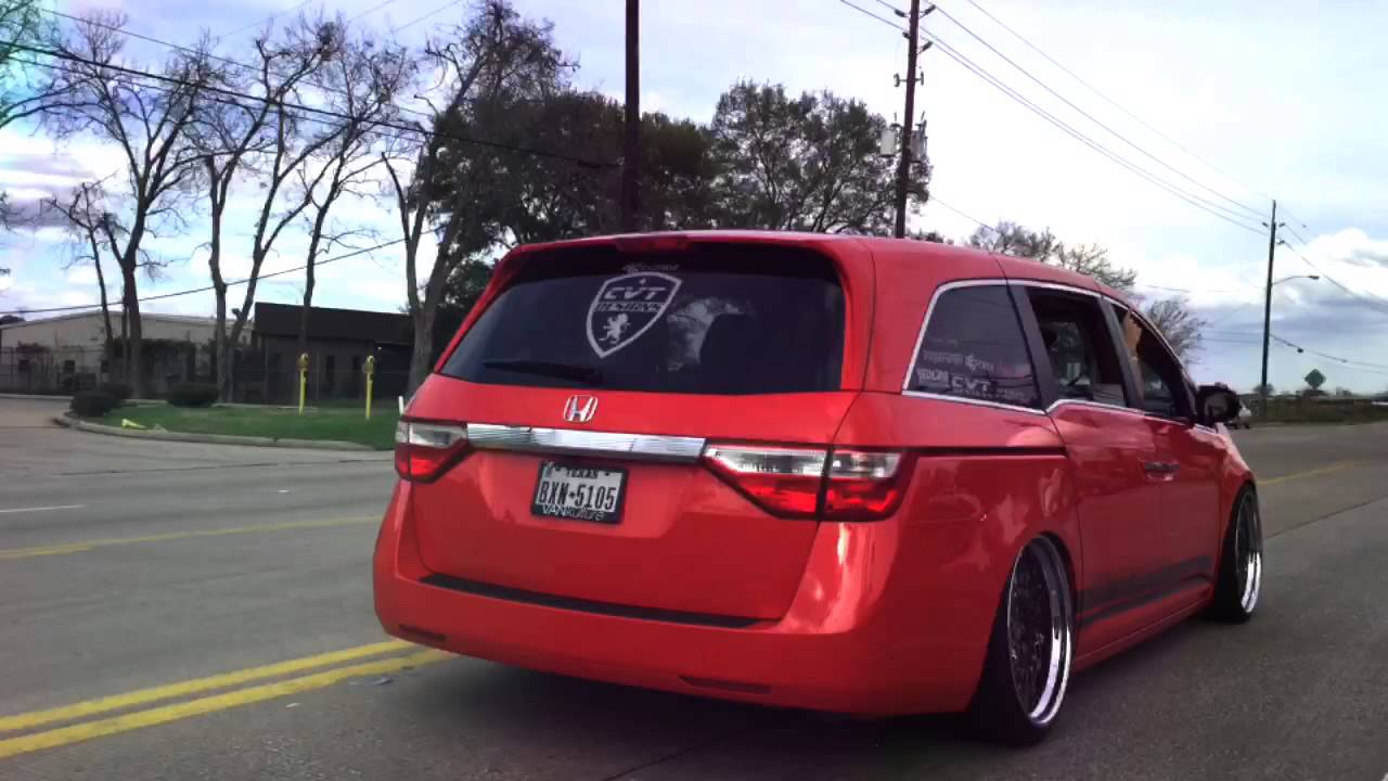 Red Honda Odyssey lowered over polished wheels, rear three-quarter view