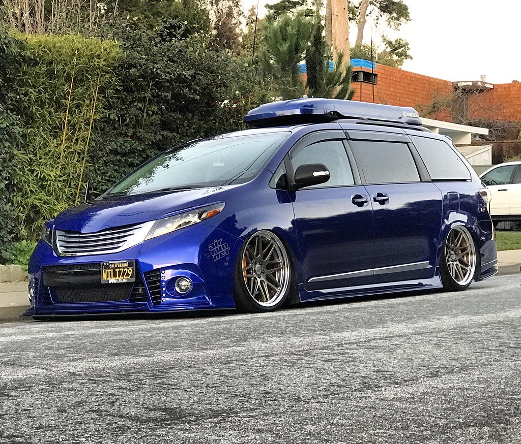 Blue Toyota Sienna on air suspension with polished wheels and a roof box