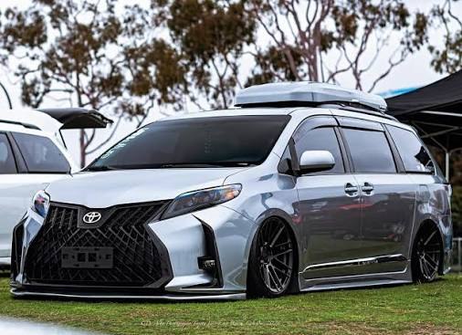 Silver Toyota Sienna with aggressive front bumper and roof box